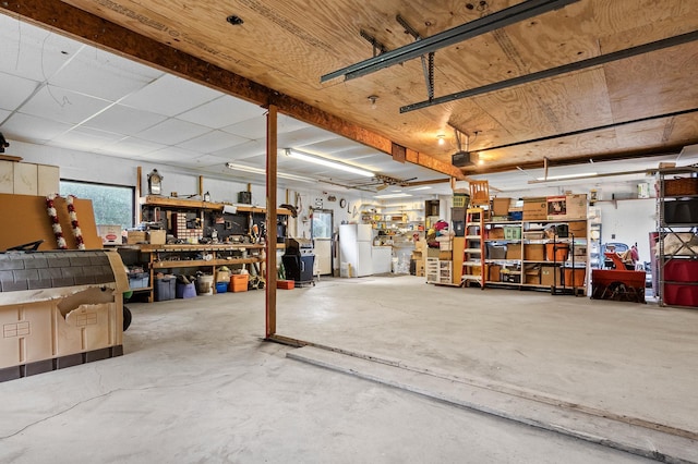3864 Archie Dr SW, Alexandria, MN 56308 - garage featuring a workshop area, freestanding refrigerator, and a garage door opener