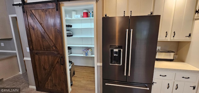 1470 Sims Rd NW, Oak Grove, MN 55011 - kitchen with refrigerator with ice dispenser, light countertops, white cabinets, and a barn door