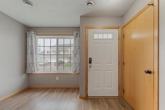 345 Roosevelt St S Unit C, Cambridge, MN 55008 - entrance foyer with wood finished floors, a textured ceiling, and baseboards