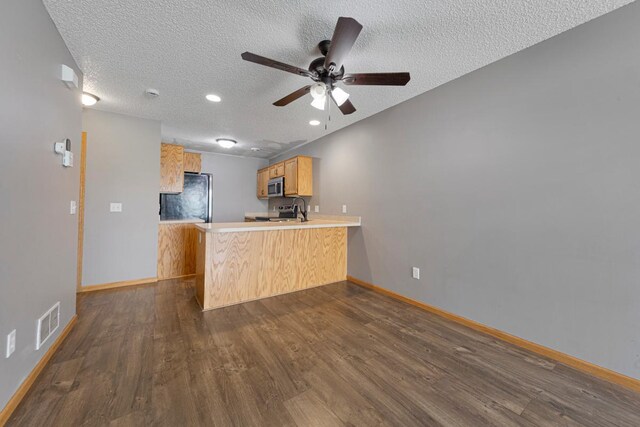 345 Roosevelt St S Unit C, Cambridge, MN 55008 - kitchen with stainless steel appliances, a peninsula, dark wood-style flooring, baseboards, and a sink
