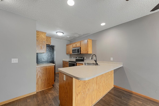 345 Roosevelt St S Unit C, Cambridge, MN 55008 - kitchen with stainless steel appliances, a sink, baseboards, light countertops, and dark wood-style floors