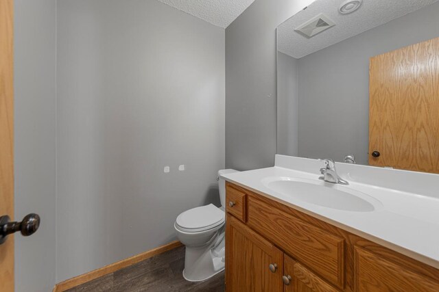 345 Roosevelt St S Unit C, Cambridge, MN 55008 - half bath featuring toilet, wood finished floors, a textured ceiling, and vanity