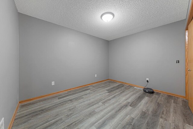345 Roosevelt St S Unit C, Cambridge, MN 55008 - empty room with wood finished floors, a textured ceiling, and baseboards