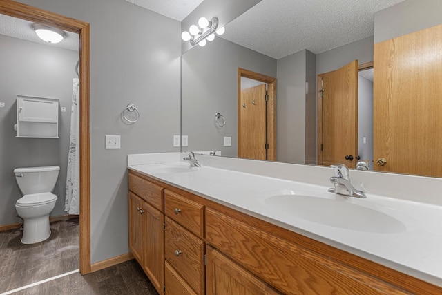 345 Roosevelt St S Unit C, Cambridge, MN 55008 - full bath with wood finished floors, double vanity, toilet, a textured ceiling, and baseboards