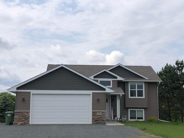 1009 188th St, Garfield Twp, WI 54009 - view of front of home with stone siding, driveway, a garage, and roof with shingles