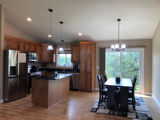 1009 188th St, Garfield Twp, WI 54009 - kitchen featuring stainless steel appliances, a kitchen island, light wood-style flooring, lofted ceiling, and dark countertops