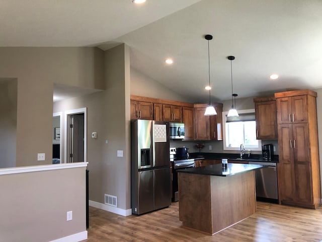 1009 188th St, Garfield Twp, WI 54009 - kitchen with stainless steel appliances, a center island, wood finished floors, dark countertops, and lofted ceiling