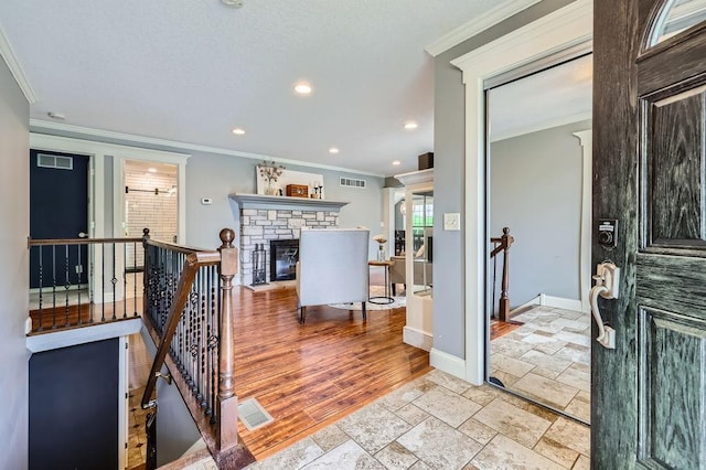 5112 Willow Ln, Minnetonka, MN 55345 - foyer with ornamental molding, recessed lighting, stone tile floors, and a stone fireplace