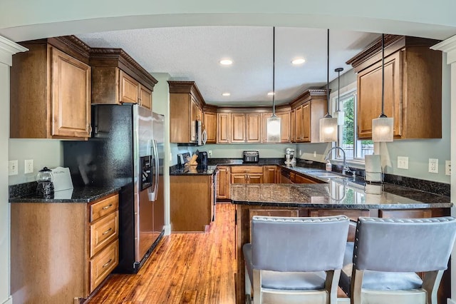 5112 Willow Ln, Minnetonka, MN 55345 - kitchen featuring stainless steel appliances, a peninsula, dark stone countertops, pendant lighting, and recessed lighting