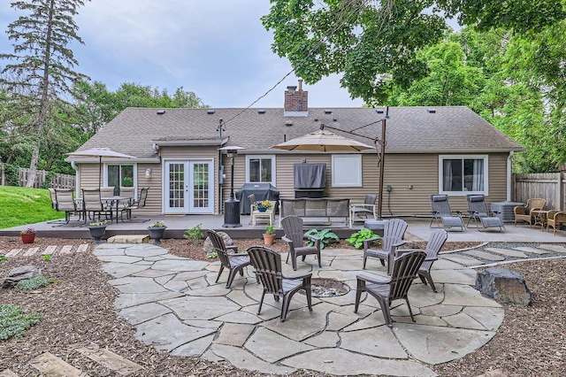 5112 Willow Ln, Minnetonka, MN 55345 - rear view of property featuring french doors, a fire pit, a patio, a chimney, and a shingled roof