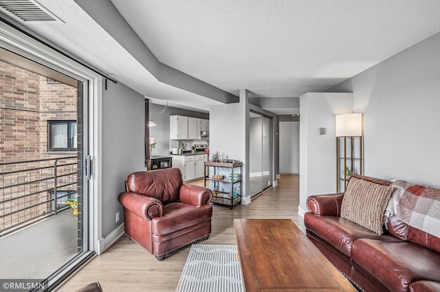 26 10th St W Unit 1409, Saint Paul, MN 55102 - living area with light wood finished floors, healthy amount of natural light, and a textured ceiling