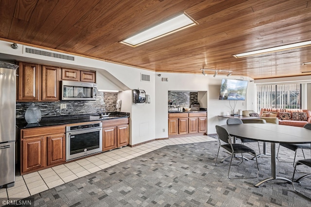 26 10th St W Unit 1409, Saint Paul, MN 55102 - kitchen featuring appliances with stainless steel finishes, wooden ceiling, light tile patterned floors, backsplash, and dark countertops