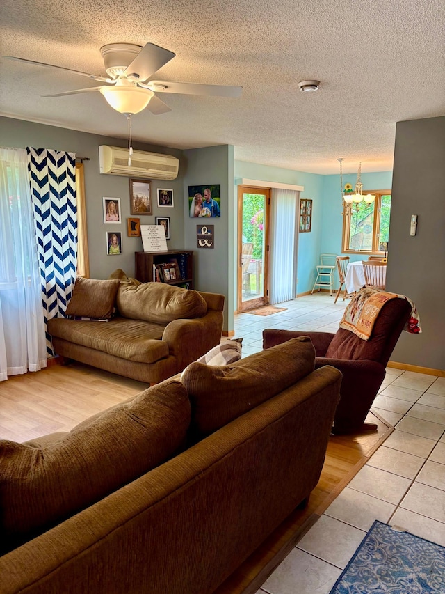 24080 Washington Dr, Osage, MN 56570 - living area featuring a wall mounted air conditioner, light tile patterned floors, ceiling fan, and a textured ceiling