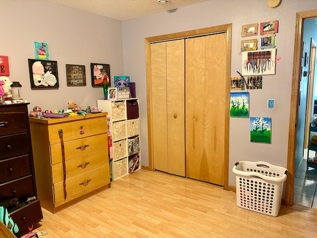 24080 Washington Dr, Osage, MN 56570 - bedroom with light wood-style floors, a closet, and a textured ceiling