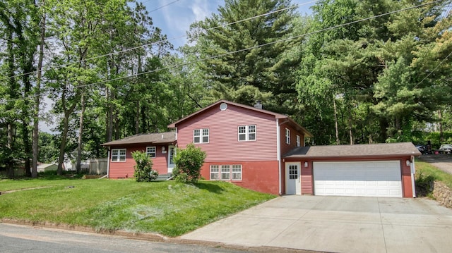 603 15th St SE, Menomonie, WI 54751 - split level home with concrete driveway, an attached garage, a front yard, and view of scattered trees