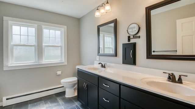 603 15th St SE, Menomonie, WI 54751 - bathroom with a baseboard heating unit, toilet, double vanity, and baseboards