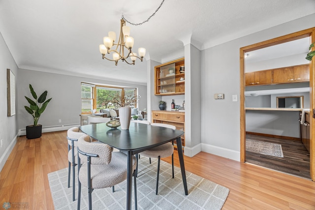 2702 2nd St N, Fargo, ND 58102 - dining area with a chandelier, light wood-type flooring, a baseboard radiator, and a baseboard heating unit