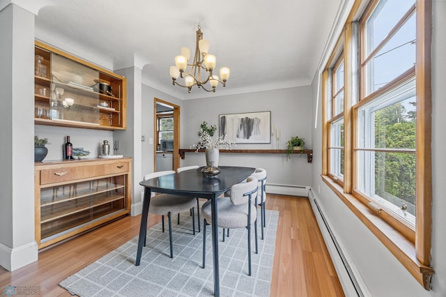 2702 2nd St N, Fargo, ND 58102 - dining space with a baseboard heating unit, a chandelier, and light wood-type flooring