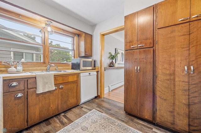 2702 2nd St N, Fargo, ND 58102 - kitchen with white dishwasher, stainless steel microwave, a baseboard radiator, dark wood-style flooring, and light countertops