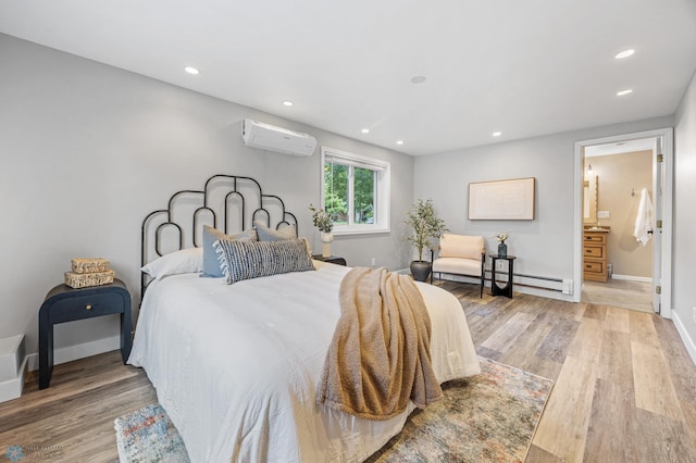 2702 2nd St N, Fargo, ND 58102 - bedroom with a wall mounted air conditioner, light wood-style flooring, recessed lighting, and connected bathroom