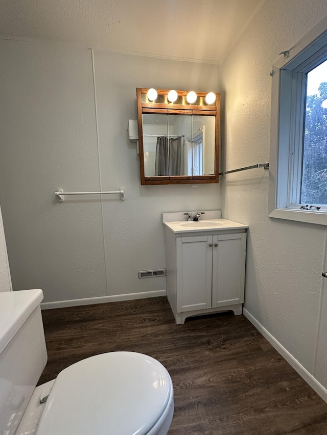 501 River St, Colfax, WI 54730 - bathroom with toilet, vanity, wood finished floors, and baseboards