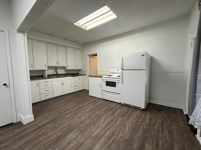 501 River St, Colfax, WI 54730 - kitchen featuring white appliances, a paneled ceiling, dark wood-style floors, dark countertops, and white cabinetry