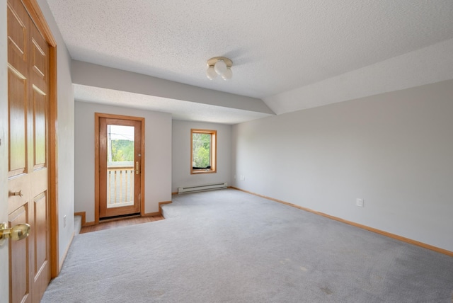 11 1st St, Nashwauk, MN 55769 - spare room featuring a baseboard heating unit, light colored carpet, and a textured ceiling