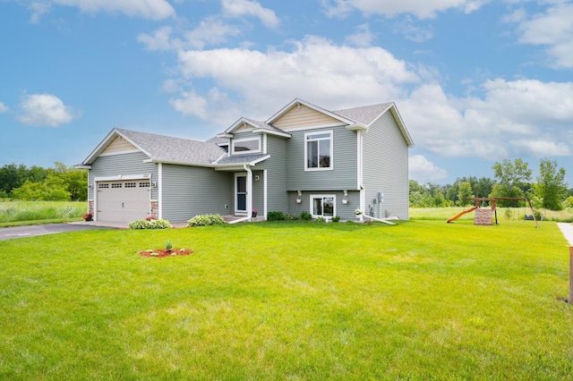 3322 Orchard Ave NE, Sauk Rapids, MN 56379 - view of front of house featuring driveway, a front yard, a garage, a playground, and roof with shingles
