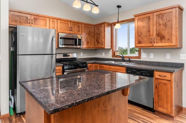 3322 Orchard Ave NE, Sauk Rapids, MN 56379 - kitchen with appliances with stainless steel finishes, light wood-style floors, brown cabinets, vaulted ceiling, and pendant lighting
