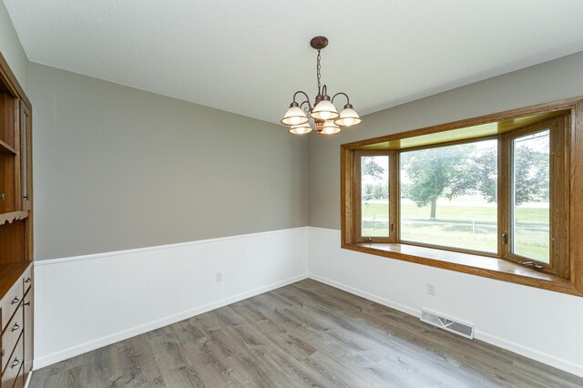 912 11 1/2 St SW, Rochester, MN 55902 - spare room featuring wood finished floors and a chandelier