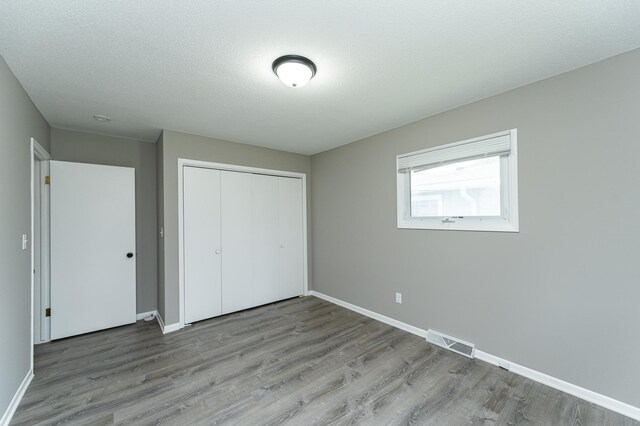 912 11 1/2 St SW, Rochester, MN 55902 - unfurnished bedroom with wood finished floors and a closet