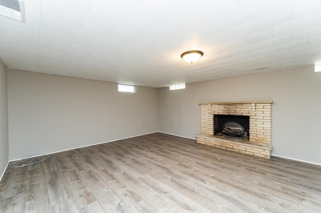 912 11 1/2 St SW, Rochester, MN 55902 - unfurnished living room with wood finished floors and a brick fireplace