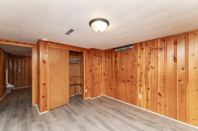 912 11 1/2 St SW, Rochester, MN 55902 - unfurnished bedroom with wood finished floors, wooden walls, and a closet