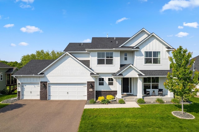 14960 143rd Ave N, Dayton, MN 55327 - view of front of home with asphalt driveway, a front lawn, an attached garage, board and batten siding, and covered porch