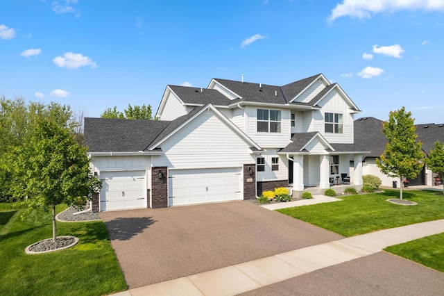 14960 143rd Ave N, Dayton, MN 55327 - view of front of property featuring driveway, stone siding, a front lawn, an attached garage, and a porch
