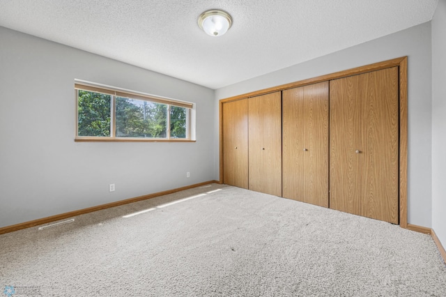 1301 5th Ave N, Moorhead, MN 56560 - unfurnished bedroom with carpet floors, a closet, and a textured ceiling