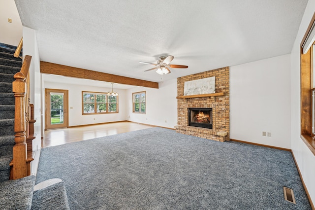 741 3rd St NE, Faribault, MN 55021 - unfurnished living room featuring carpet flooring, stairs, a ceiling fan, a fireplace, and a textured ceiling