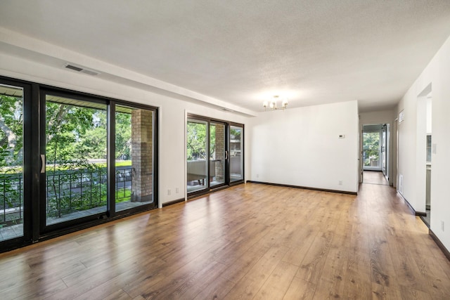 6417 Colony Way Unit 2A, Edina, MN 55435 - unfurnished room featuring a chandelier, wood finished floors, and baseboards