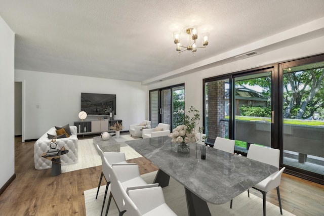 6417 Colony Way Unit 2A, Edina, MN 55435 - dining room with a chandelier, wood finished floors, and a textured ceiling
