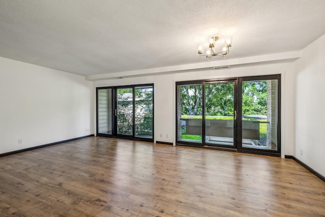 6417 Colony Way Unit 2A, Edina, MN 55435 - spare room with a chandelier, a textured ceiling, wood finished floors, and baseboards