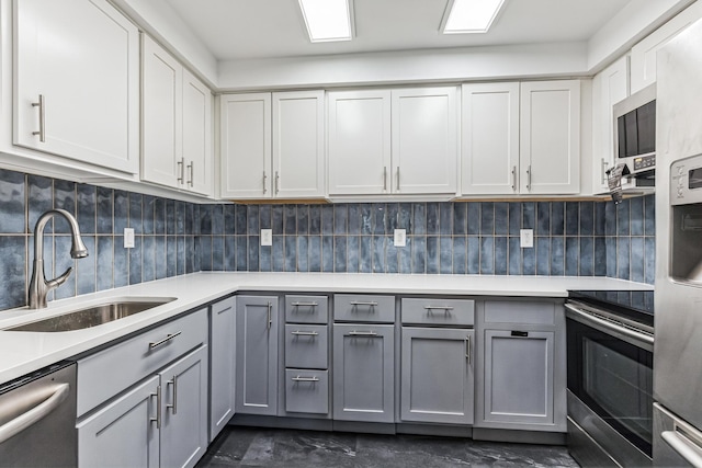 6417 Colony Way Unit 2A, Edina, MN 55435 - kitchen with gray cabinets, stainless steel appliances, a sink, light countertops, and decorative backsplash