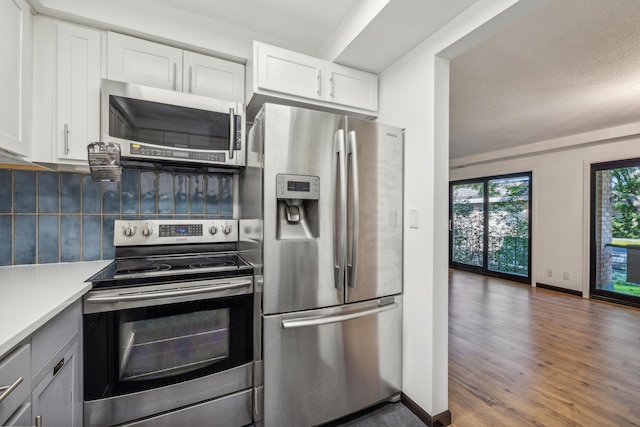 6417 Colony Way Unit 2A, Edina, MN 55435 - kitchen with appliances with stainless steel finishes, tasteful backsplash, white cabinets, and wood finished floors