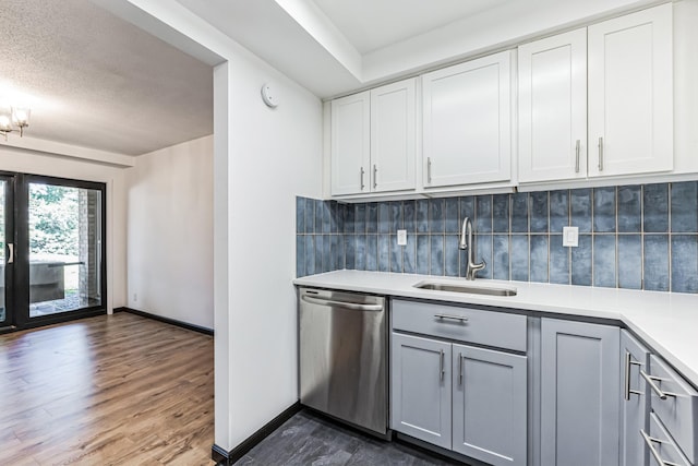 6417 Colony Way Unit 2A, Edina, MN 55435 - bar featuring dishwasher, a sink, dark wood-type flooring, and decorative backsplash