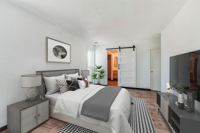 6417 Colony Way Unit 2A, Edina, MN 55435 - bedroom with a barn door, light wood finished floors, and ensuite bathroom
