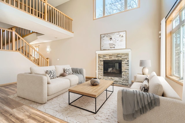 604 Crane Creek Ln, Eagan, MN 55121 - living area featuring a towering ceiling, wood finished floors, stairway, and a glass covered fireplace
