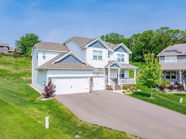 882 Redmond Dr, Carver, MN 55315 - view of front of home with driveway, covered porch, a front yard, and board and batten siding