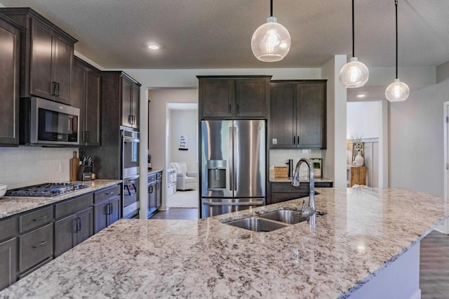 882 Redmond Dr, Carver, MN 55315 - kitchen featuring stainless steel appliances, a sink, wood finished floors, light stone counters, and a textured ceiling