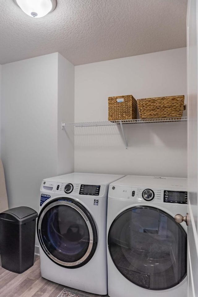 882 Redmond Dr, Carver, MN 55315 - laundry area featuring independent washer and dryer, light wood-type flooring, and a textured ceiling