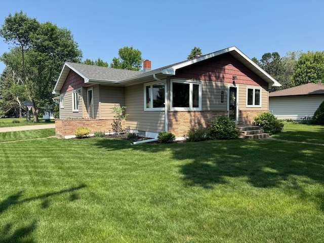 401 5th St NE, Barnesville, MN 56514 - view of front of house featuring a chimney, a front yard, and brick siding