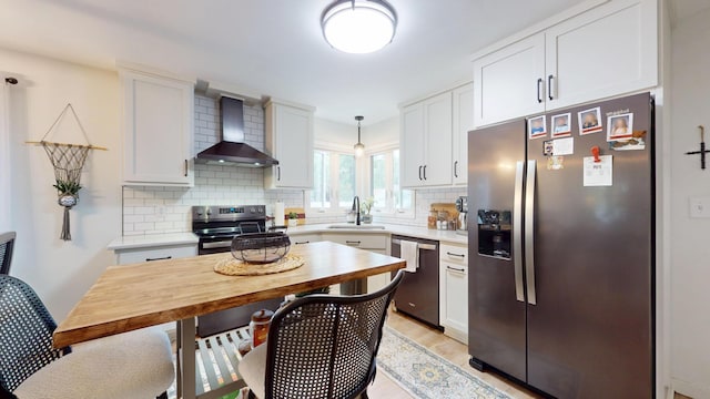 401 5th St NE, Barnesville, MN 56514 - kitchen with appliances with stainless steel finishes, wall chimney range hood, a sink, decorative backsplash, and white cabinets